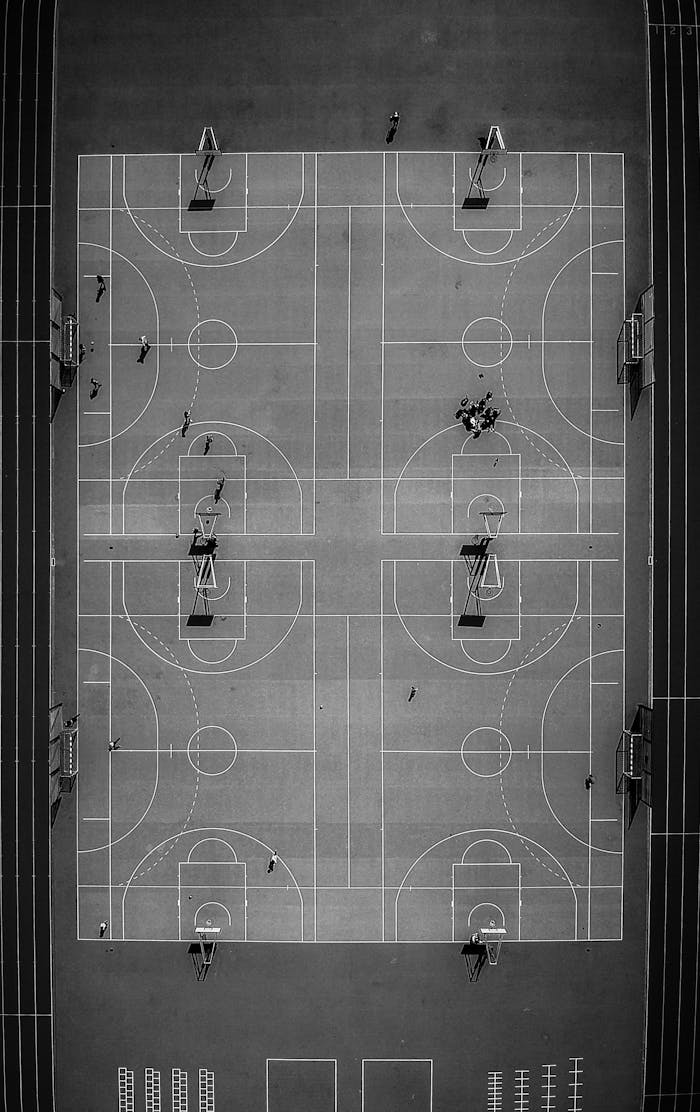 Home Drone captures a striking black and white aerial view of a basketball court in Chamonix, France, highlighting its symmetry.
